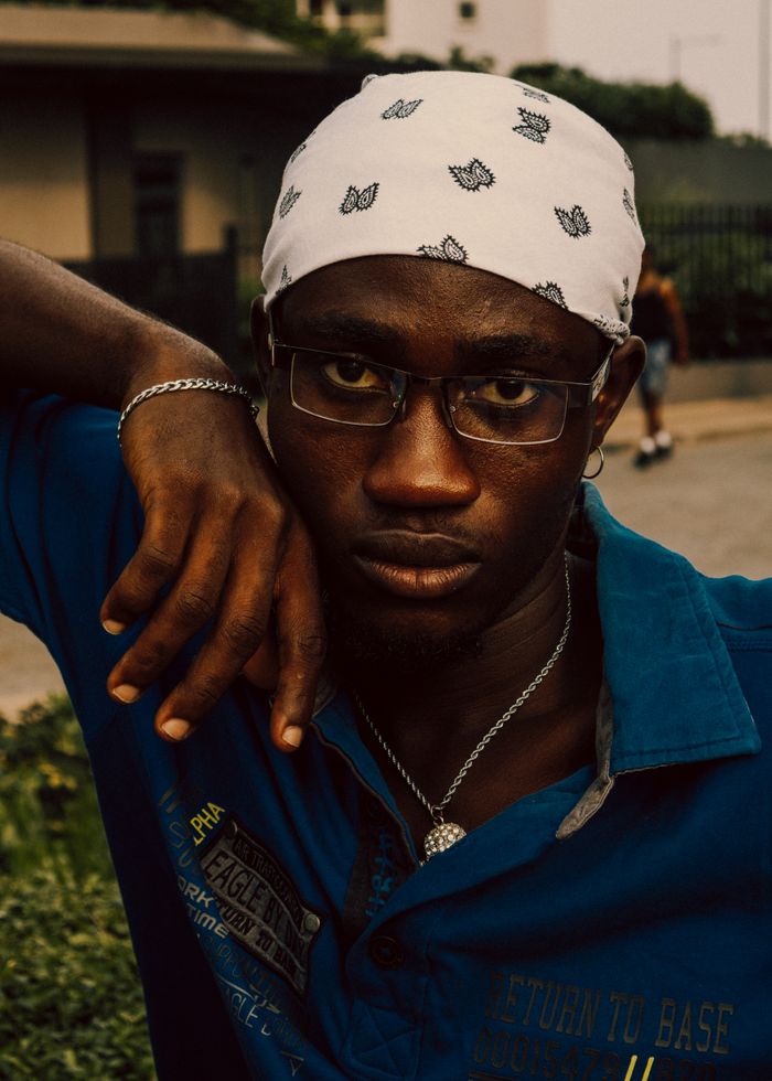 services-03 Portrait of a young man with bandana and glasses in Accra, Ghana, exuding confidence in urban setting.