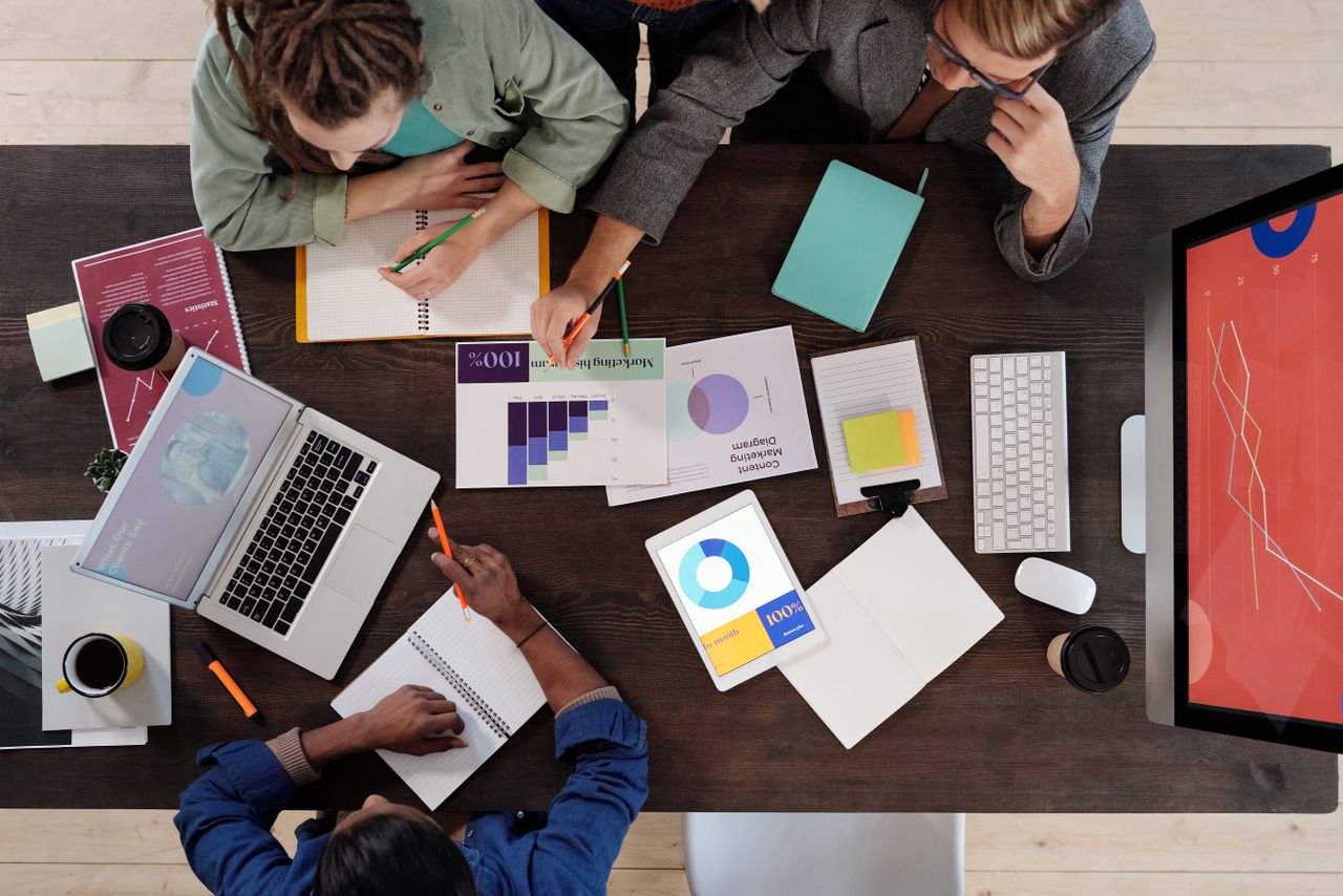 why-choose-us Overhead view of a diverse team collaborating on a project in a modern office setting.